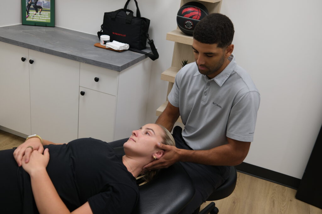 Dr Aden adjusting a female patient's neck