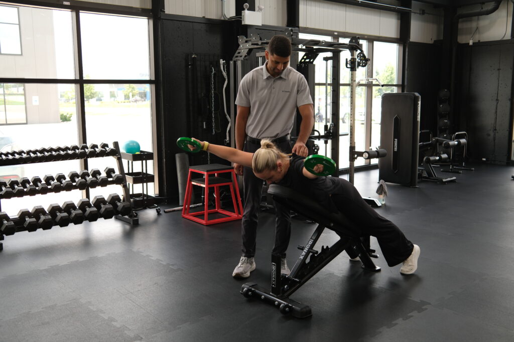 Chiropractor working with a patient in a gym