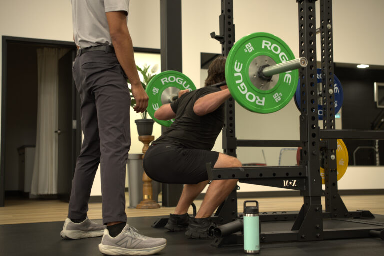 Chiropractor guiding an athlete on exercises